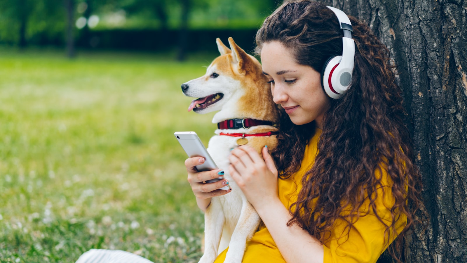 a woman with headphones is holding a dog