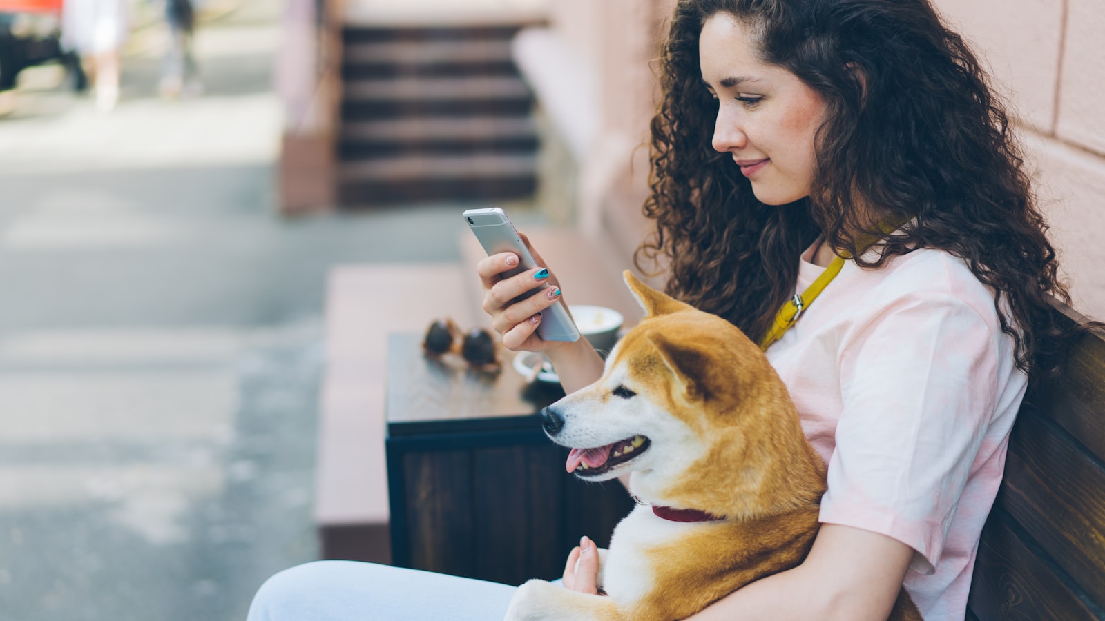 a woman sitting on a bench holding a dog