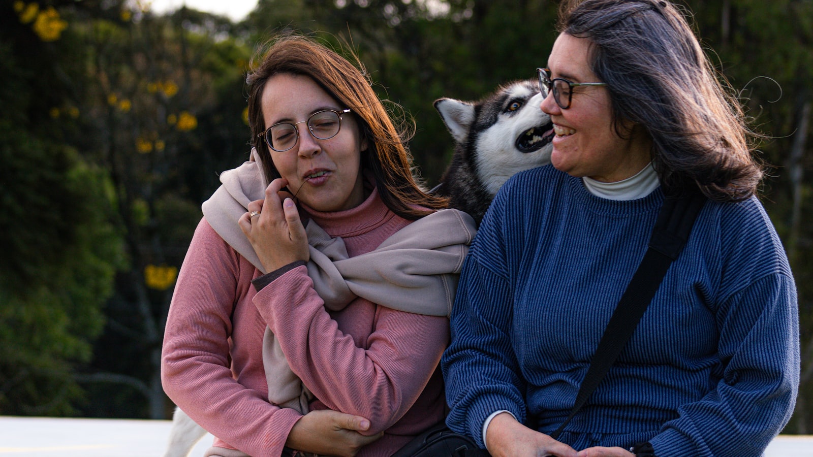 Two women and a husky dog outdoors